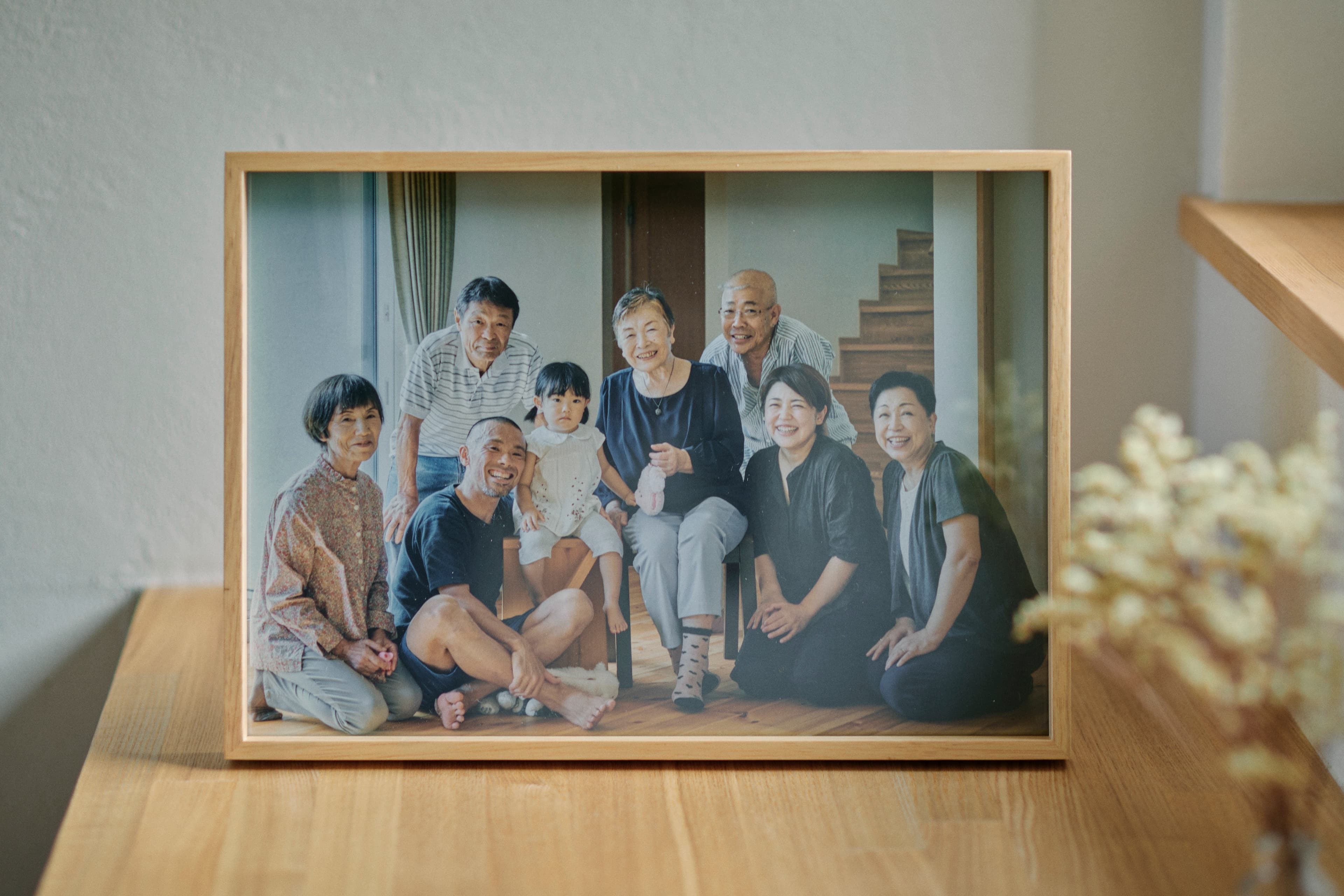 木の棚に置かれた額入りの家族写真