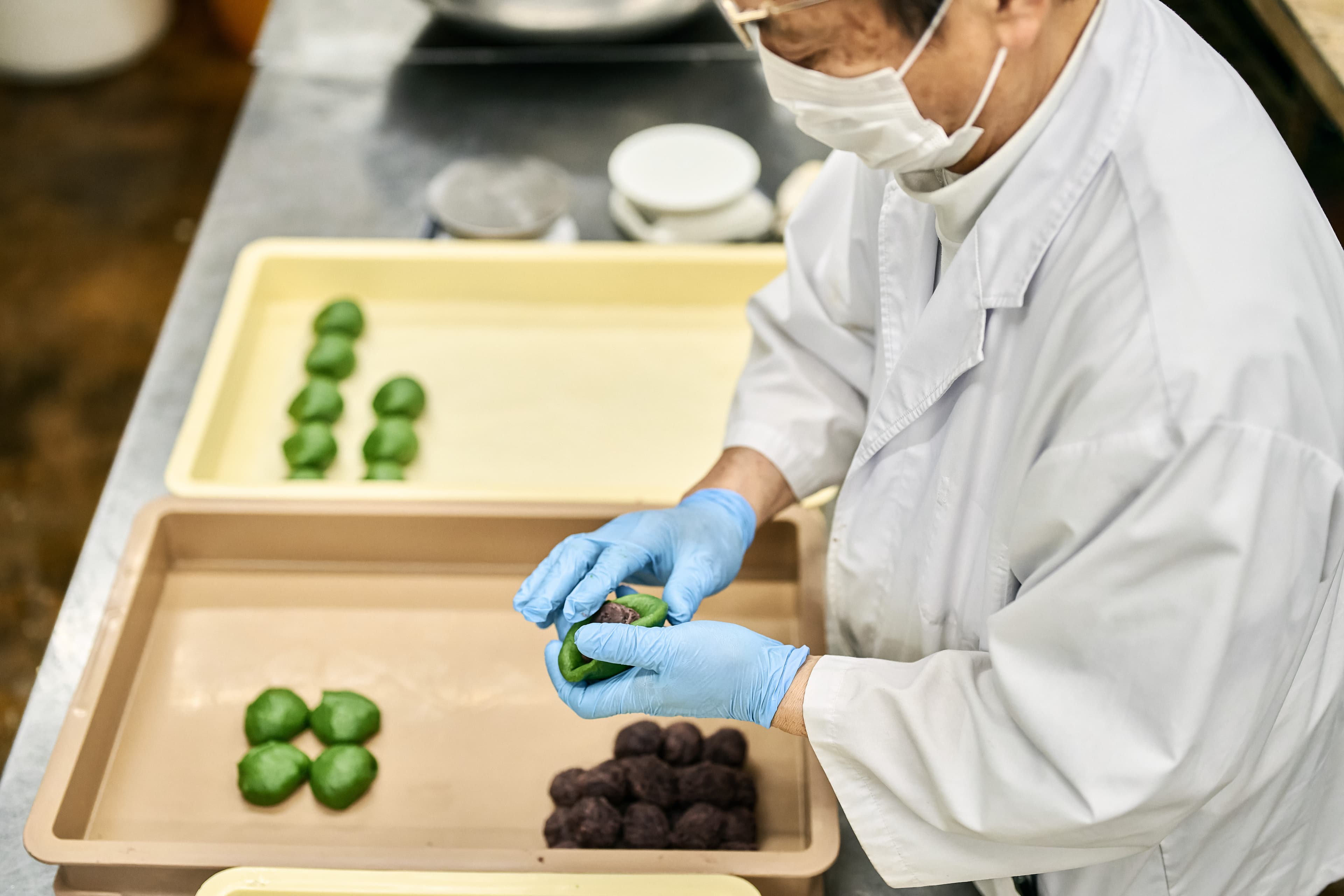菓子を一つずつ手で整える作業者