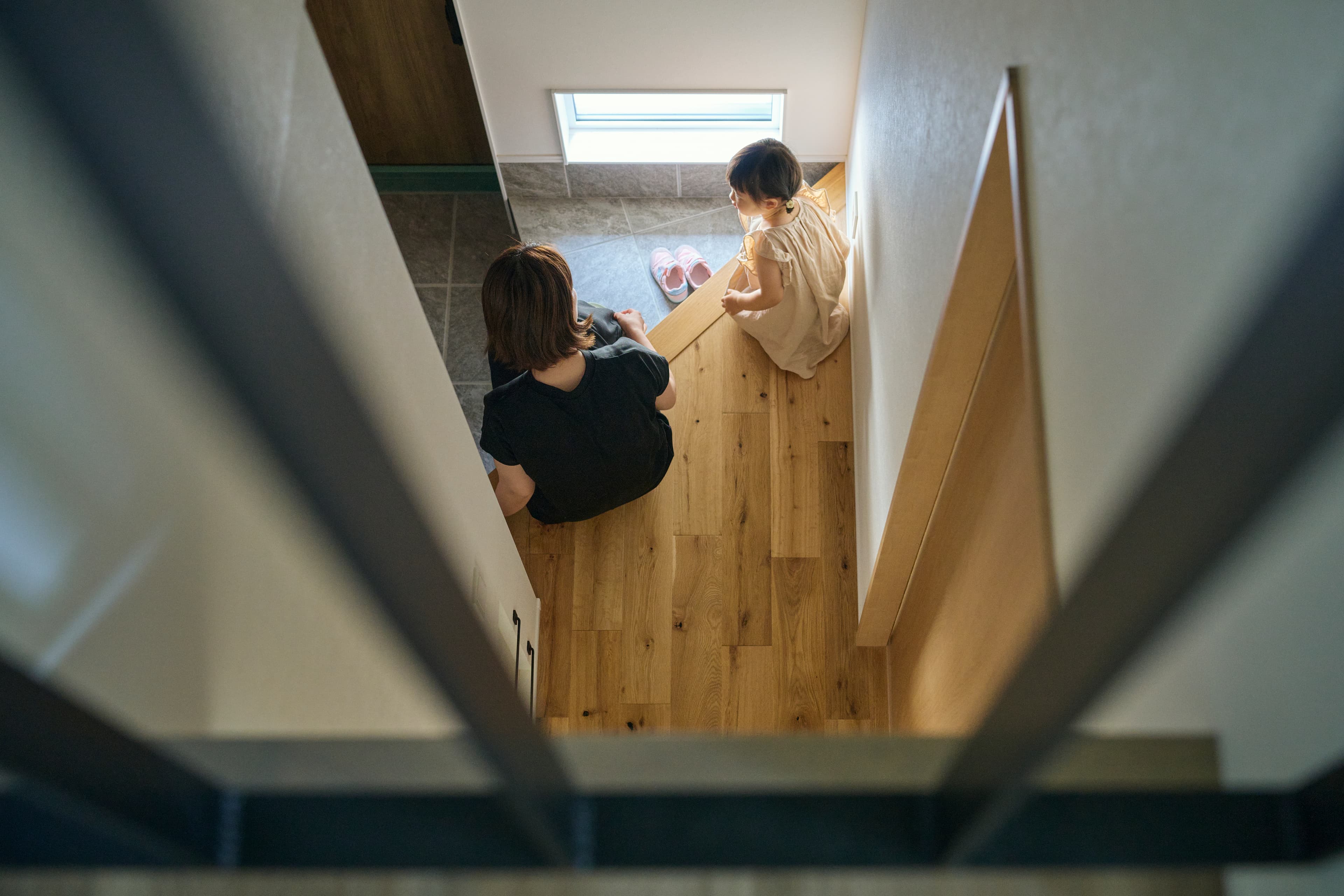 階段の途中で本を読む親子
