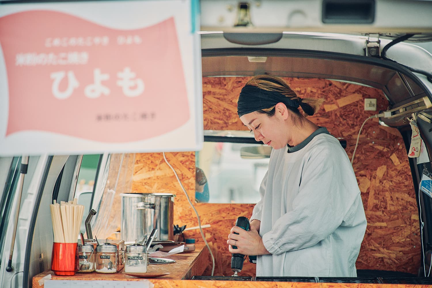 キッチンカーの中で飲み物を用意する人物