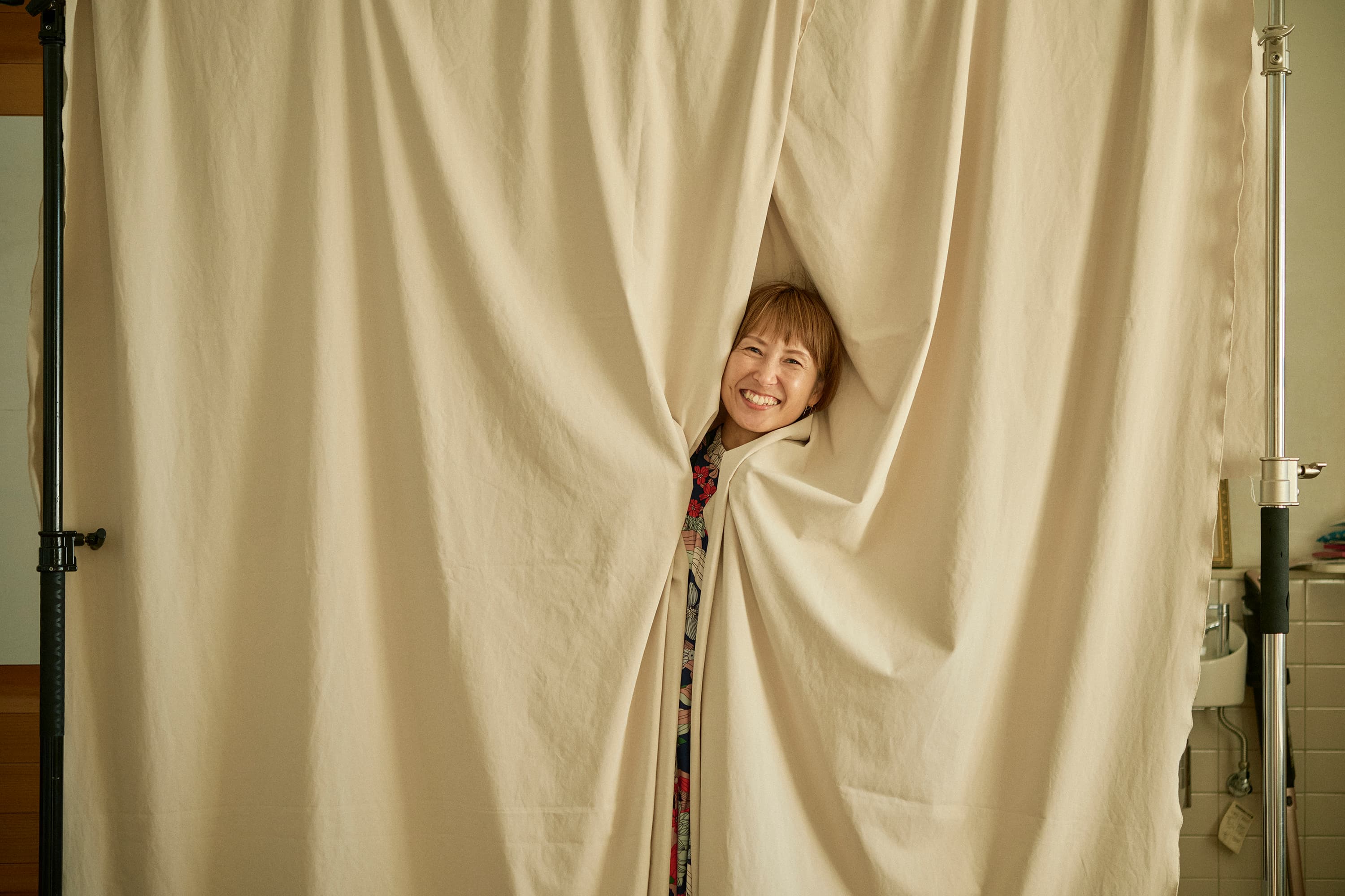 布の間から顔をのぞかせる人物