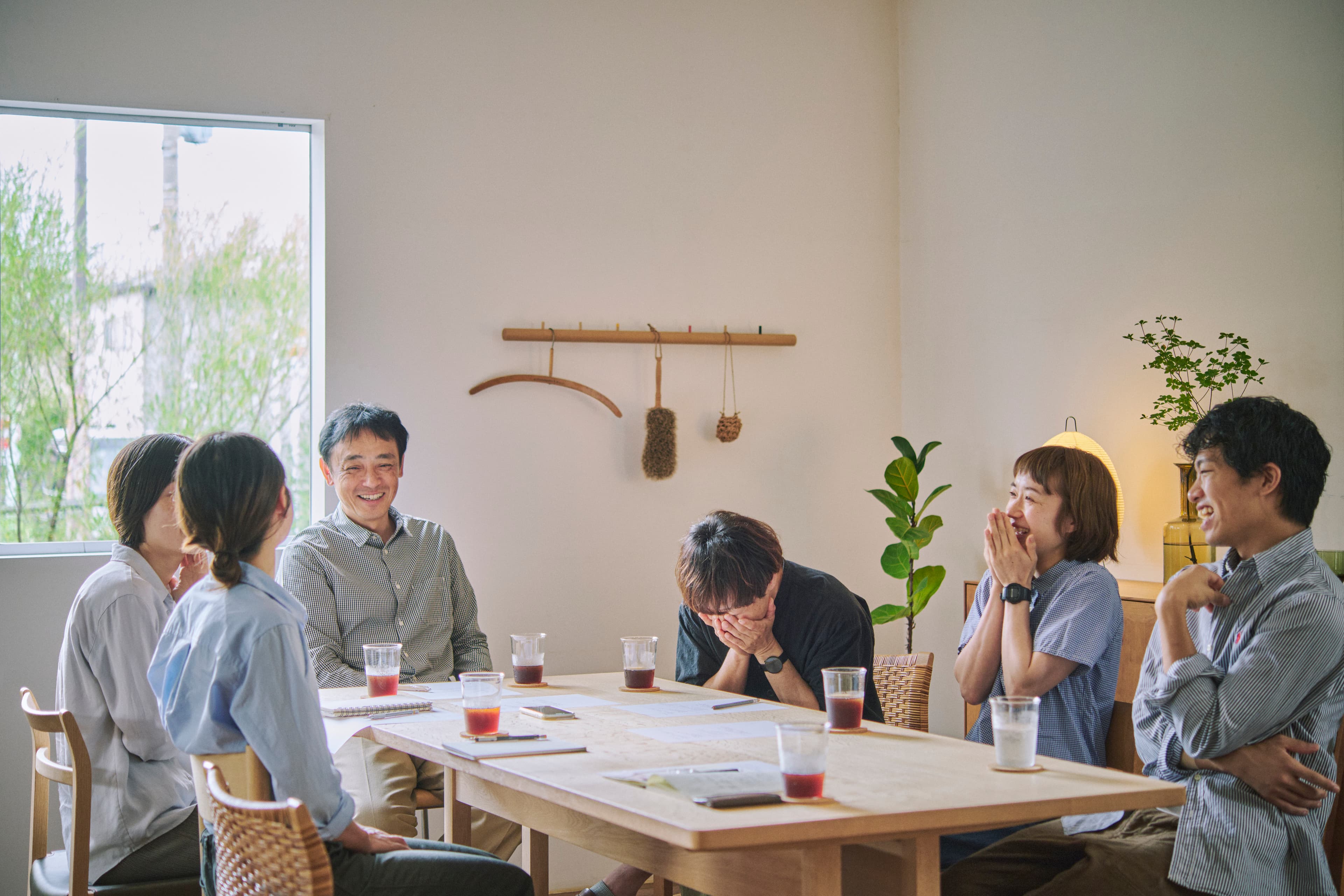 テーブルを囲み笑いながら話す人々