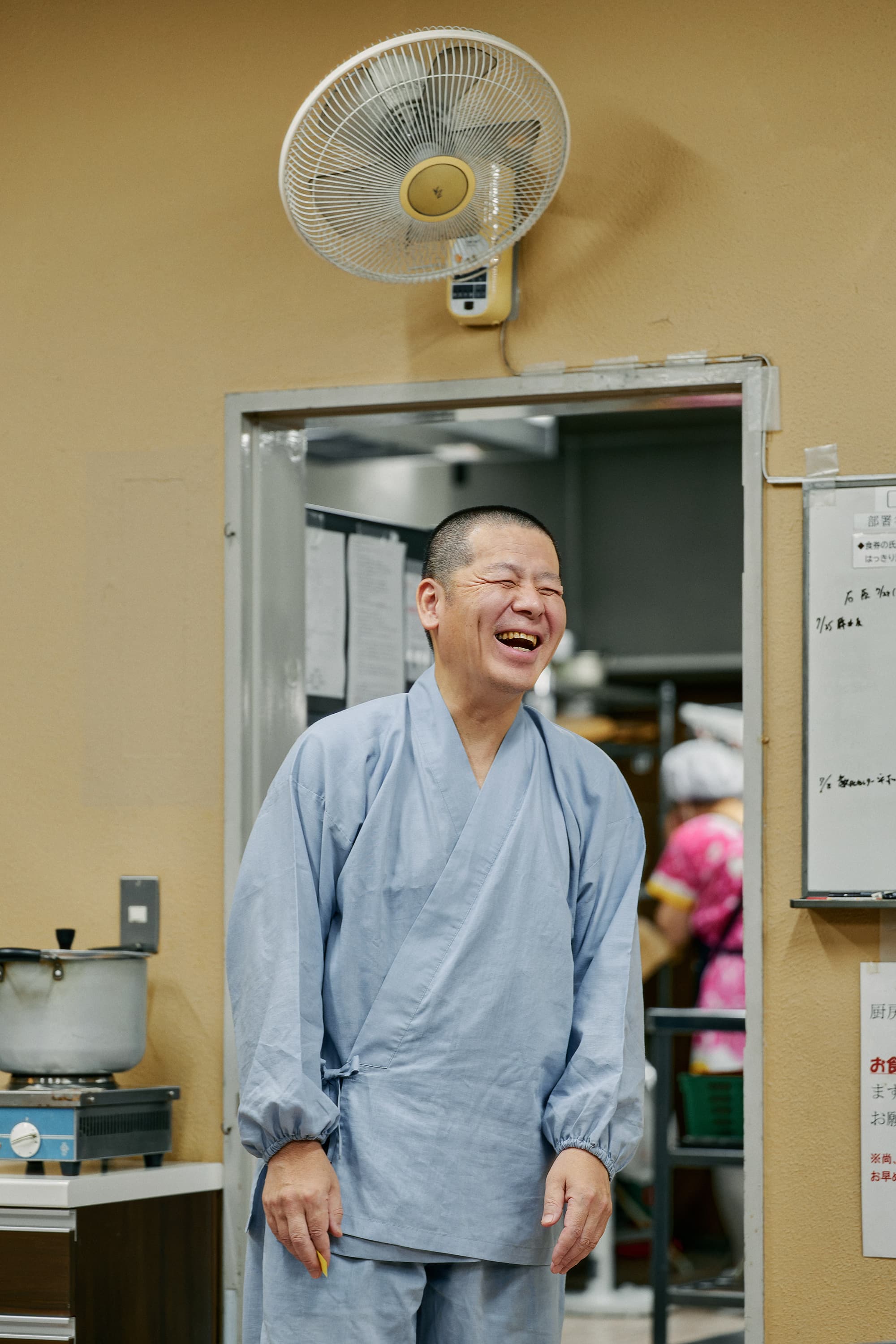 厨房の入口で笑う僧侶