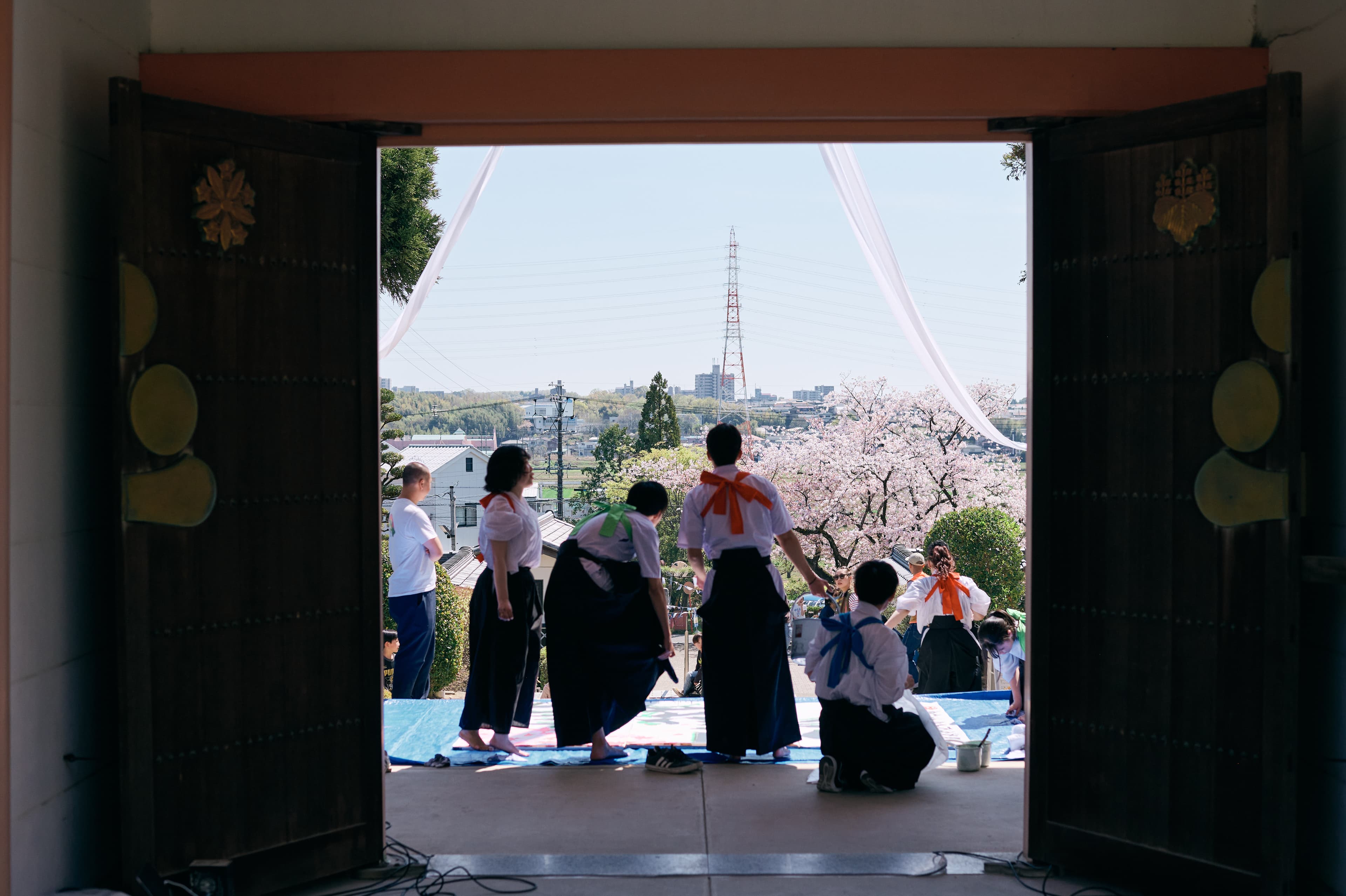 建物の入口越しに見える桜と人々