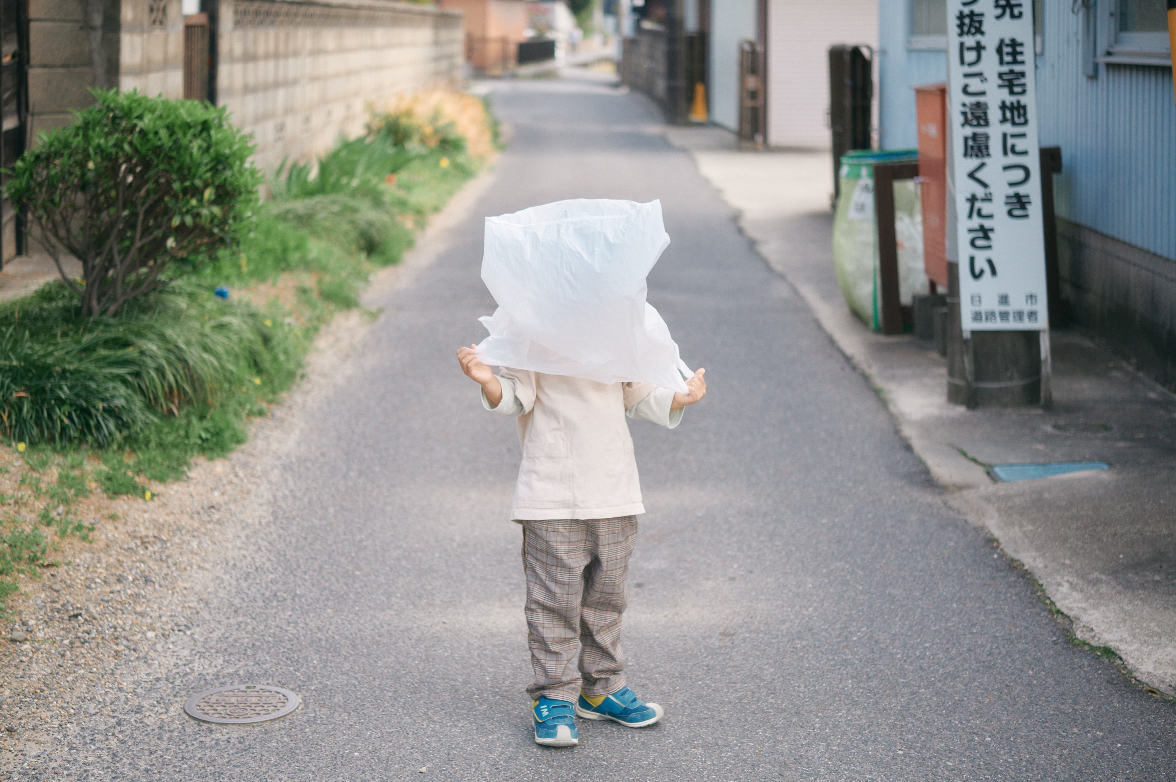 道の上で白い布をかぶる子ども