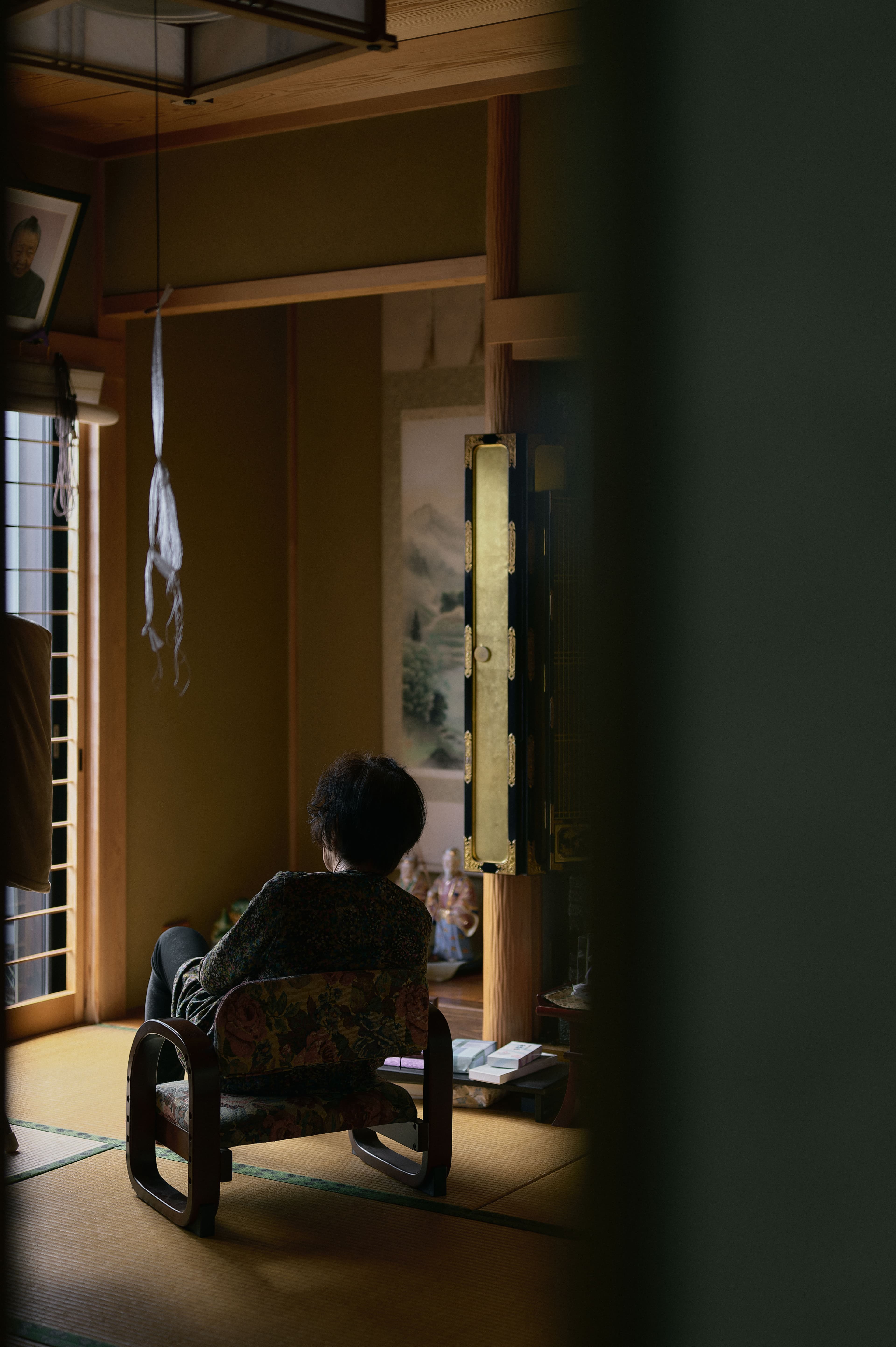 室内の椅子に座る人の後ろ姿