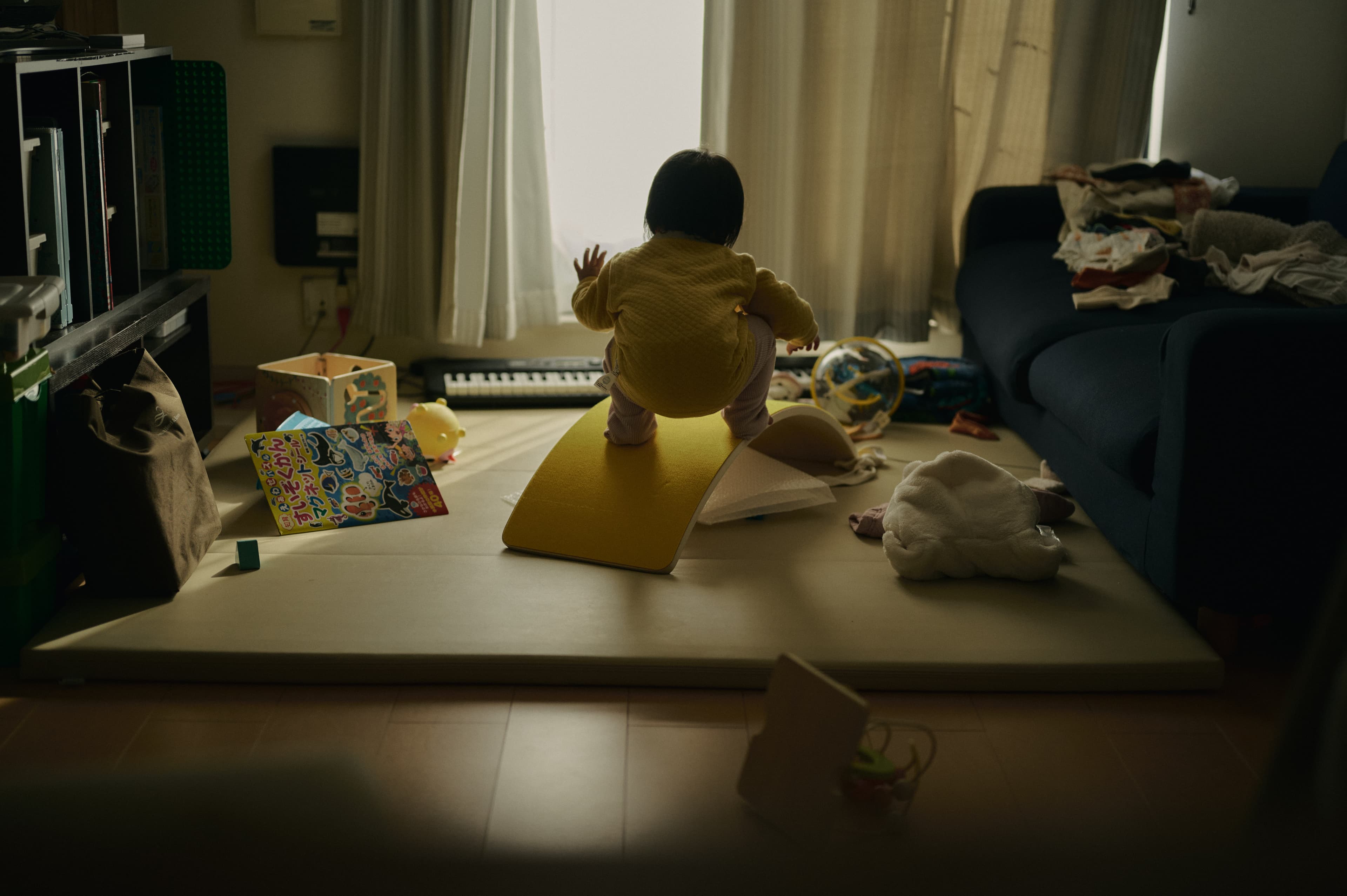薄暗い室内の床で過ごす子どもたち