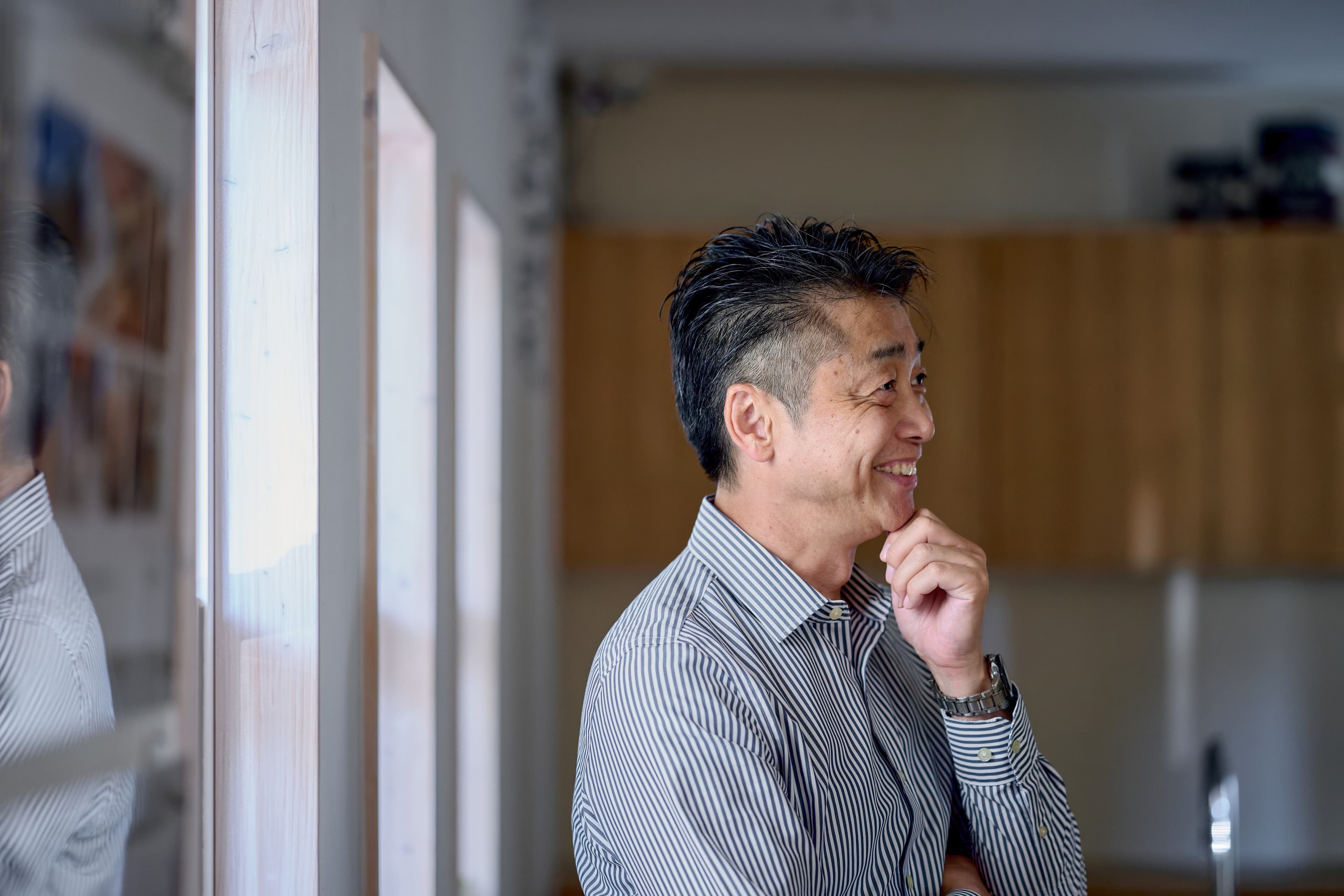 窓辺で笑顔を見せる男性